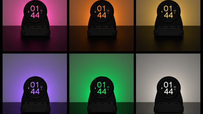Black digital clock displaying '01:44' on a black background with colorful lighting.