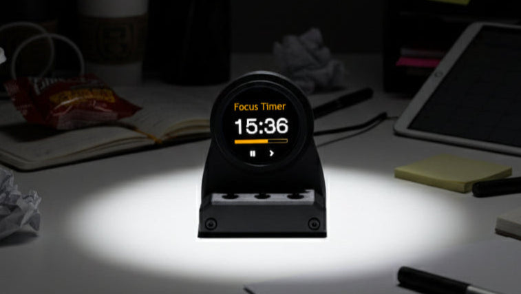 DeskOrbie focus timer on a desk with a dark background