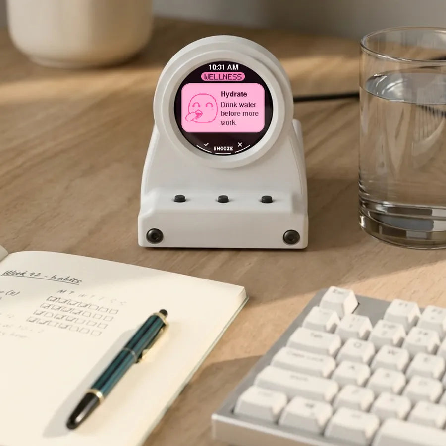 Frost White DeskOrbie 2 reminding you to drink water, beside a glass of water and a keyboard